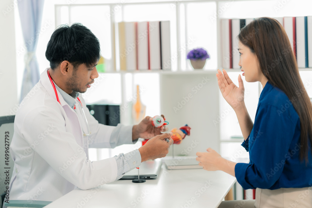 Obraz premium A middle-aged male doctor is diagnosing a disease while consulting a female patient in a clinic, describing her bone-related pain and taking notes in the clinic.