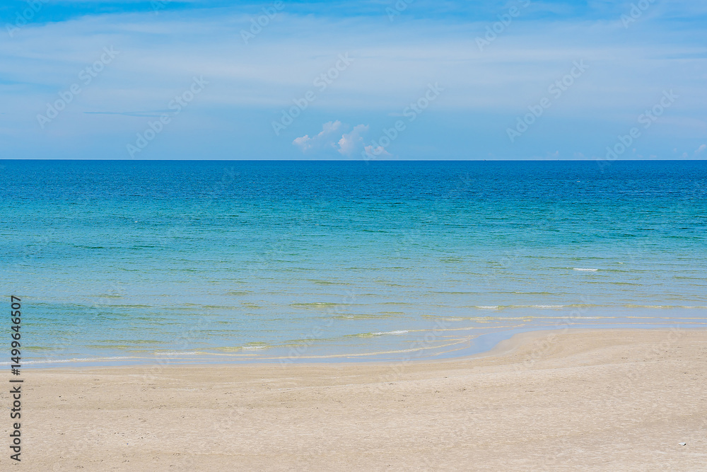 Fototapeta premium Beautiful nature of the sea in summer, with sunlight, sandy beaches, and sparkling water contrasting against the blue sky.
