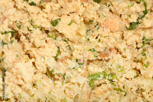 A thoroughly mixed preparation for bread dumplings, featuring moist bread, chopped herbs, and other binding ingredients
