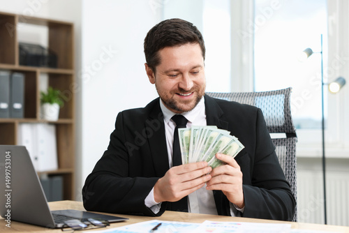 Greedy banker counting money and smiling at table in office