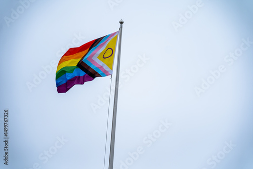 Pride Flag Displayed Proudly Against Pale Sky on Bright Day