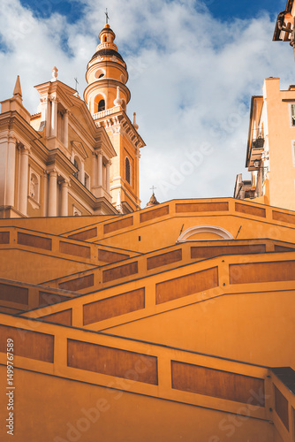 yellow staircase to tge church in the town of mentone, french riviera, on a sunny day