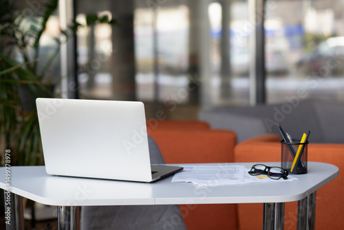 Stylish workspace with laptop computer, office supplies, houseplant and books at office. Desk work concept.