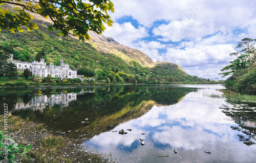 Kylemore Abbey, a stunning neo-Gothic castle nestled in the lush Connemara mountains of western Ireland, reflected beautifully in the still waters of a nearby lake. photo