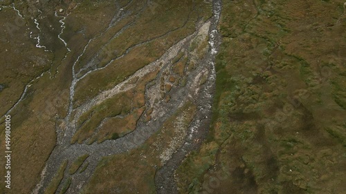Wide alpine stream flows through green Norwegian valley