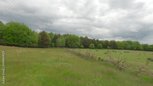Epic aerial view of vibrant green fields with lush grass, captured in dynamic motion. Perfect for nature, agriculture, and scenic landscape projects.
