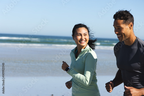 Couple jogging on beach, smiling and enjoying sunny morning workout together, copy space