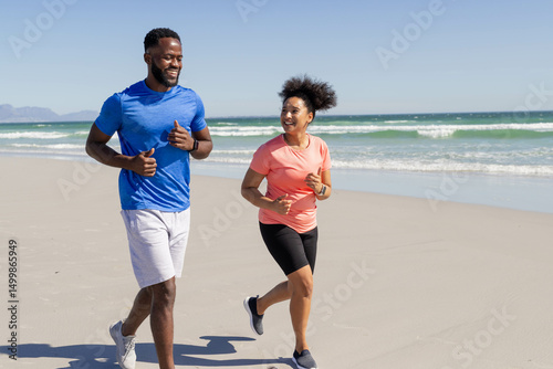 Couple jogging on beach, enjoying sunny day and staying active together photo