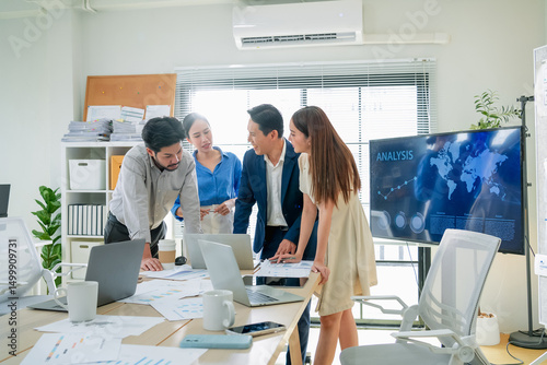 Focused business strategists stand head-to-head in a modern office, concentrating on agile planning and financial structure, using AI to forecast results and align team goals for success business team