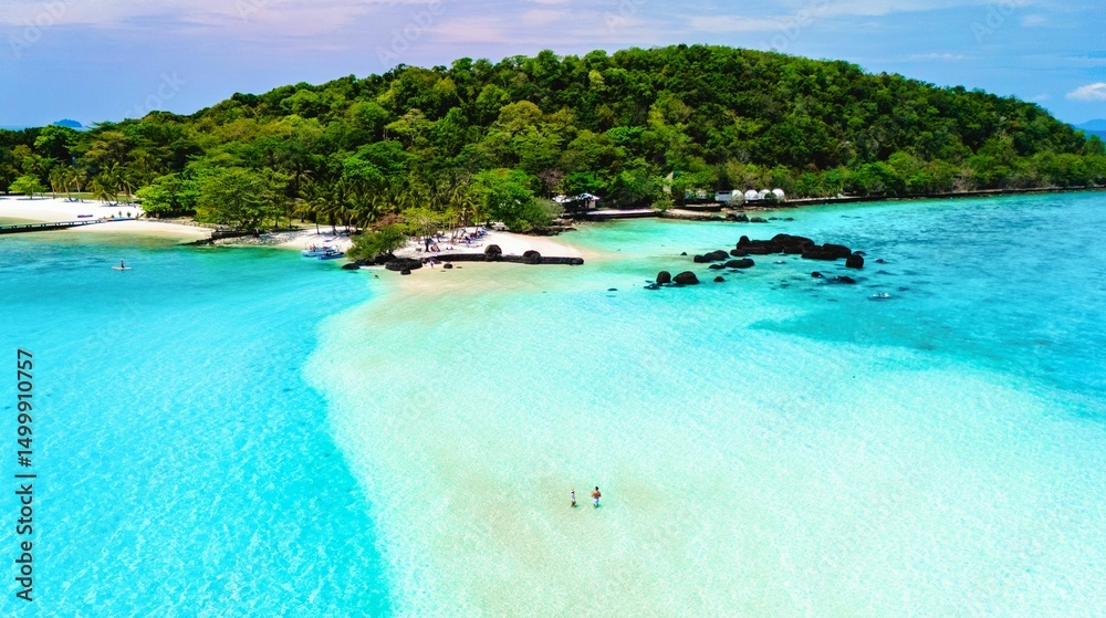 Fototapeta premium Turquoise waters gently lap against a tranquil shoreline, where two individuals enjoy the warm sun. Lush green mountains rise behind, Koh Kham Island near Koh Mak Thailand