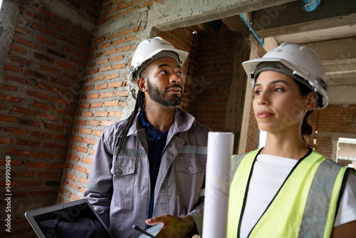 Two Engineer builder. Foreman use notebook computer working in construction site.	