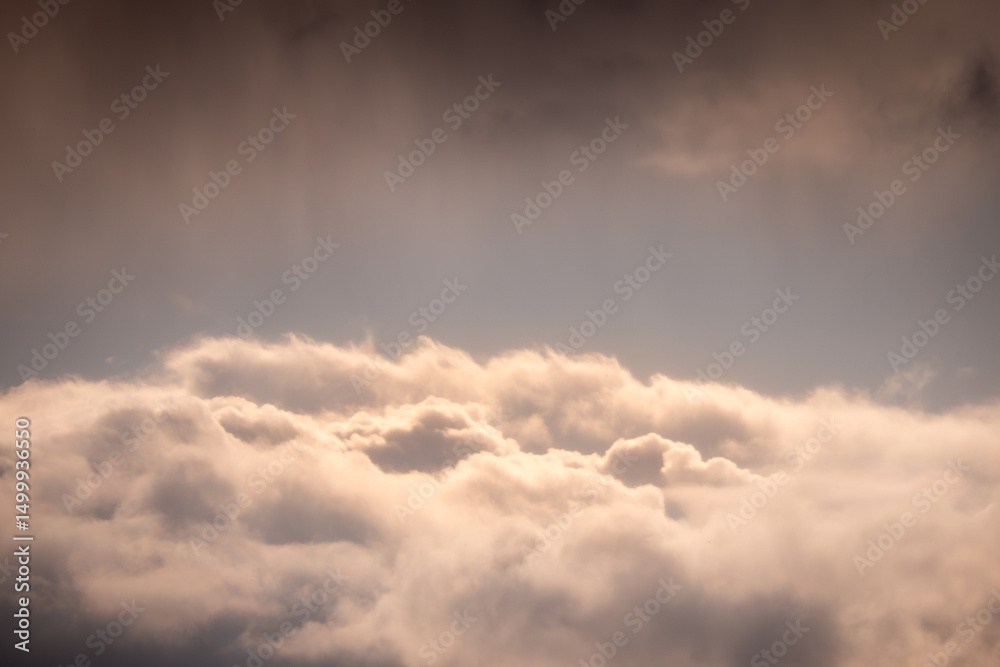Obraz premium Bright clouds with soft sunlight breaking through a dark sky. A symbolic view of heaven often linked to faith, hope, divine light, and spiritual meaning.