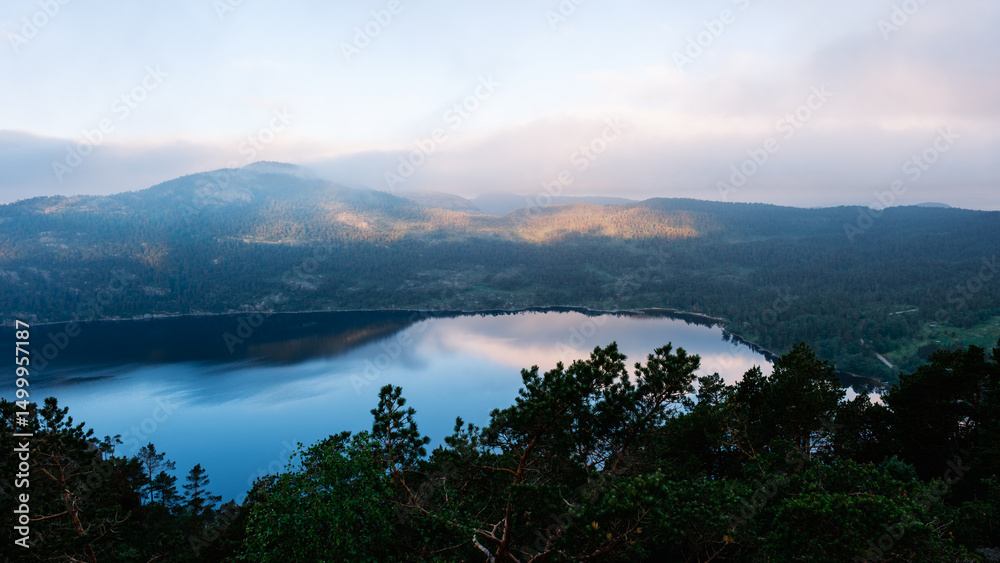 Obraz premium Majestic view over tranquil lake reflecting mountains in Norway at dawn