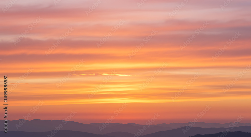 Fototapeta premium Panoramic Mountainscape at Dusk with Vibrant Orange and Pink Sky Tones