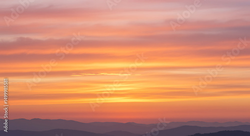 Panoramic Mountainscape at Dusk with Vibrant Orange and Pink Sky Tones