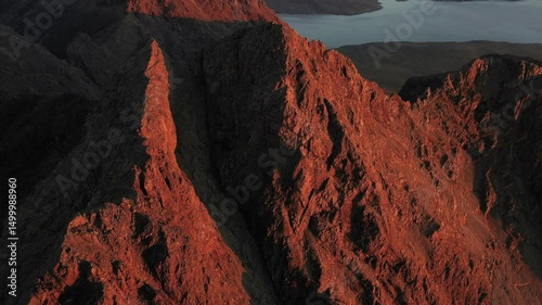 The Cuillin Ridge on the Isle of Skye at Sunset - Jagged peaks of the Scottish Highlands catching the last orange light of the day and the sun set over the Sea photo