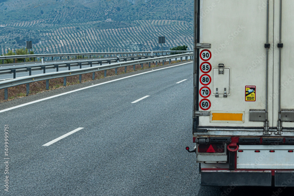 Φωτογραφία Rear view of a refrigerated truck driving on the highway, displaying maximum speed limit stickers, mandatory in some non EU countries