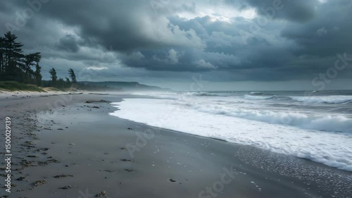 Dramatic seascape showcasing crashing waves on a tranquil grey sandy beach under a stormy sky