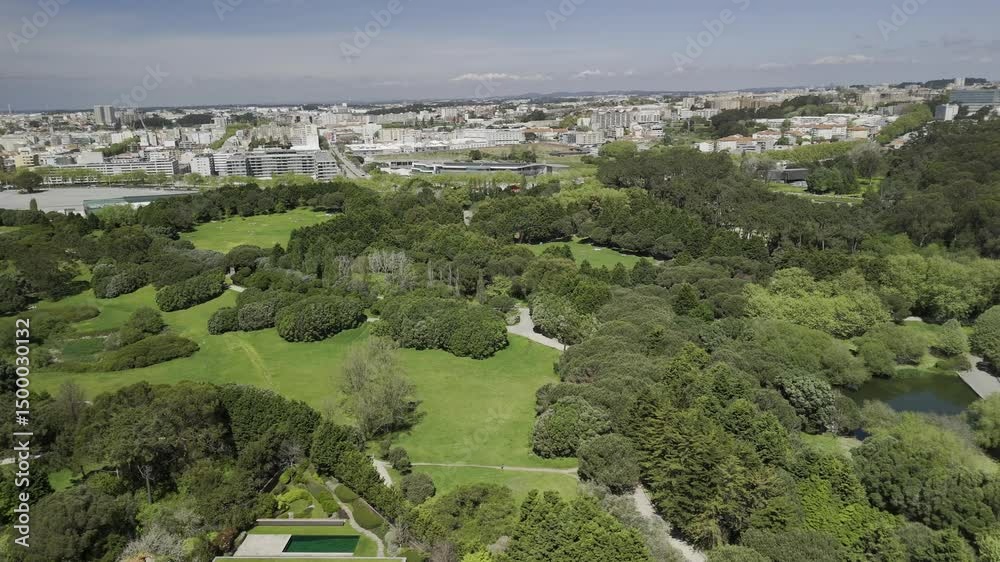 Drone facing north flies to the right along the Parque da Cidade do Porto on sunny day in Porto, Portugal