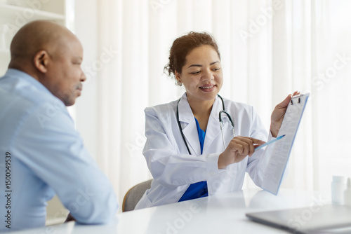 Smiling Doctor Woman Discussing Medical Test Results With Happy Male Patient In Clinic, Female Therapist In Uniform Holding Clipboard And Demonstrating Complete Blood Count Range To Mature Man