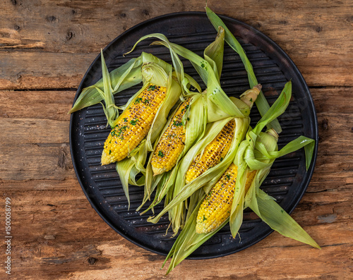 Grilled corn with butter, herbs and himalayan salt. Summer vegan dinner or snack.
