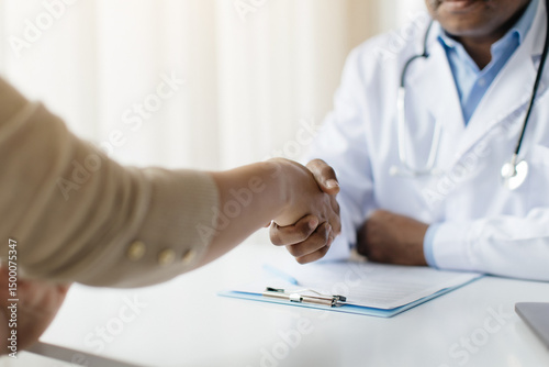 Medical Services Concept. Doctor Man And Female Patient Handshaking During Meeting In Clinic, Black Male Therapist Wearing White Coat Welcoming Young Woman In His Office, Cropped Shot