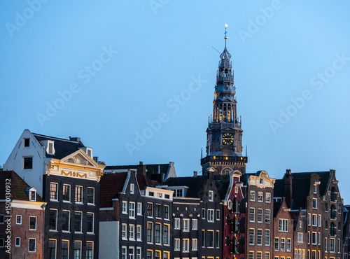 The old church tower with old town canal house during blue hour, Amsterdam, travel
