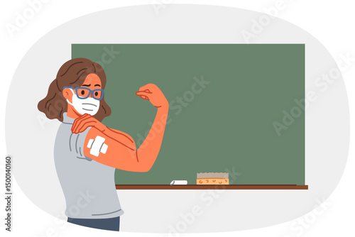 Vaccinated female teacher demonstrates patch at injection site on arm, standing near school board. Vaccinated girl teacher recommends taking preventive measures to protect against virus