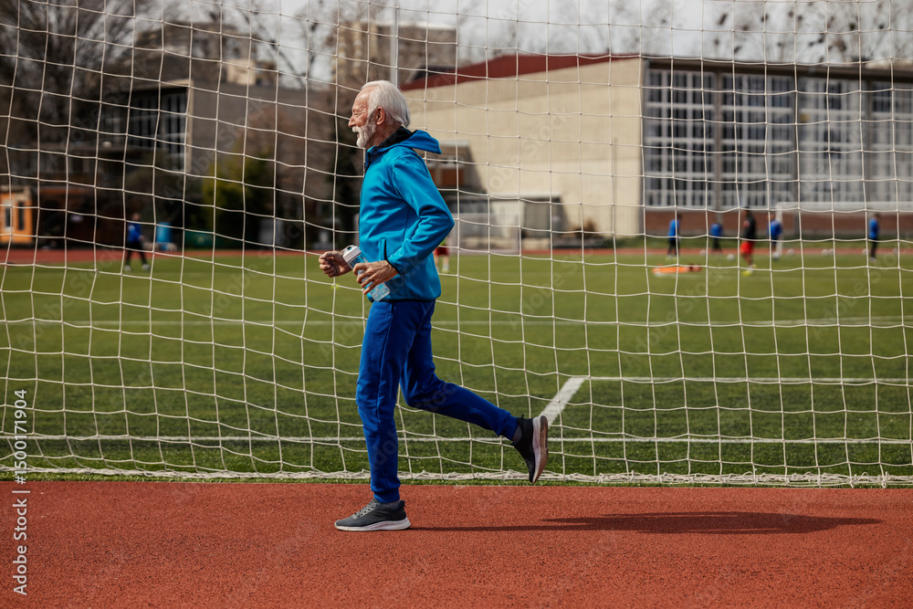 Obraz premium Fit senior runner running on stadium.