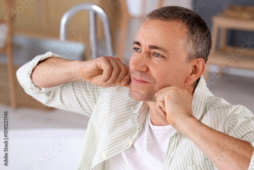 Happy mature man doing face...