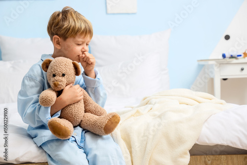 Photos Little boy ill with chickenpox and toy bear coughing in bedroom