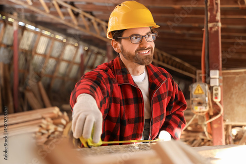 Male carpenter measuring wo...