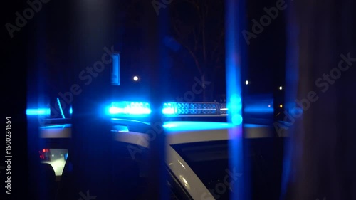 Close-up of blue police lights flashing in the dark. Emergency beacons glow with intense color and reflections, symbolizing law enforcement, urgency, and public safety.

