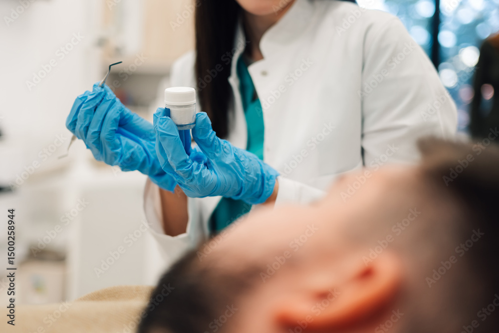 Fototapeta premium Dentist holding dental instruments and filling material getting ready for operation