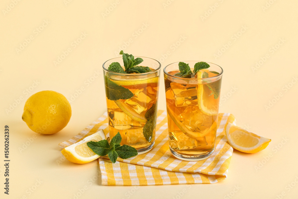 Fototapeta premium Glasses of lemon ice tea with mint on beige background