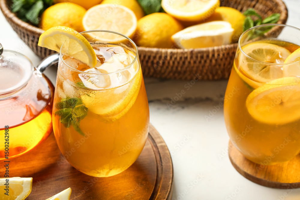 Fototapeta premium Glasses of lemon ice tea with mint and citrus fruits on white background, closeup