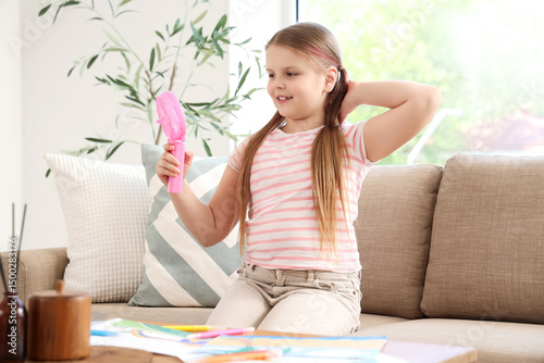 Cute girl with mini fan sit...
