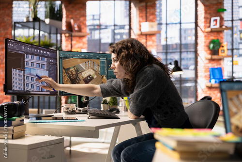 Фотография Woman uses architectural software on her PC to create a detailed 3D render of a home interior