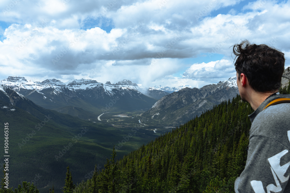 Naklejka premium A hiker admires the Rockies and river valley below.