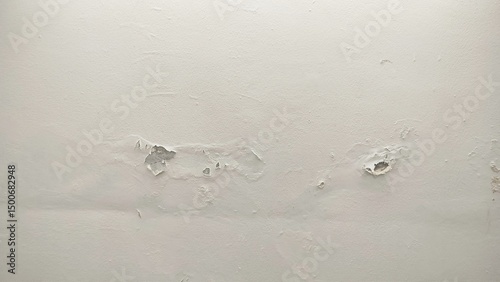 The surface or background of an old white wall with peeling paint. photo of a damp and moldy house wall