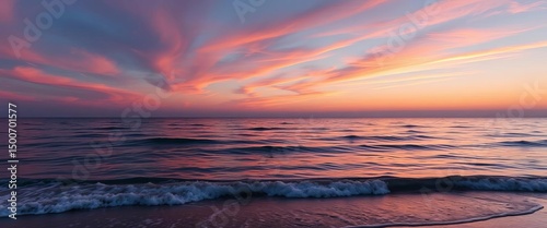 Serene sunset hues paint a calm ocean horizon, gentle waves lapping shore, clear sky, coast photo