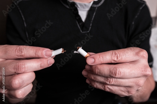 Concept image of a man cutting the habit of quitting smoking. Burning cigarette with smoke and concept of cigarettes 