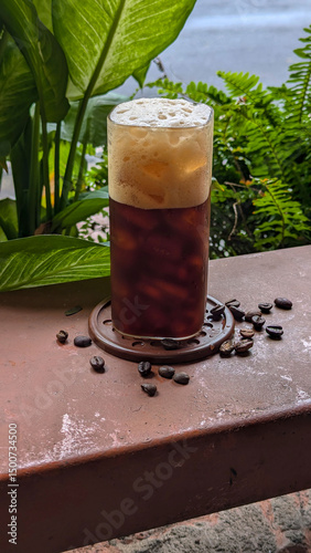 Coffee cups and coffee beans with a background of greenery