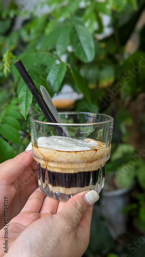 Hold the coffee cup with a layer of cheese cream on top.