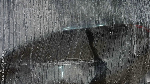 Closeup View Of A Wet Dirty Car Window With Streaks And Reflection In A Vertical Frame. The Dark Toned Glass Displays Grunge Texture Creating An Abstract And Mysterious Visual Effect