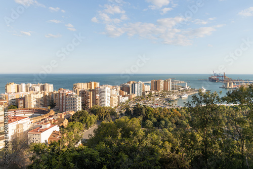 Malaga at sunset. Scenic coastal view showcasing vibrant cityscape with lush greenery and serene waters, embodying the essence of summer relaxation and leisure