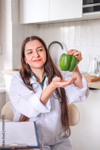 Close-up of green pepper in hands of Doctor nutritionist, dietitian, health benefits of eating fresh vegetables. Diet, eating behavior, vitamins.