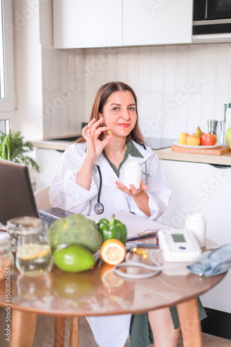 Doctor holding transparent yellow oval capsules and white jar in hand. food supplements, vitamin D, omega-3, fish oil.
