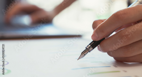 Businessperson writer signing the book and the documents on the table.