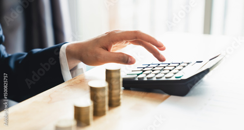 Accountant hand using calculator and money coin stack with copy space, Saving money concept.